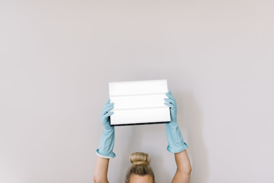 Woman with rubber cleaning gloves holds up cinema lightbox.