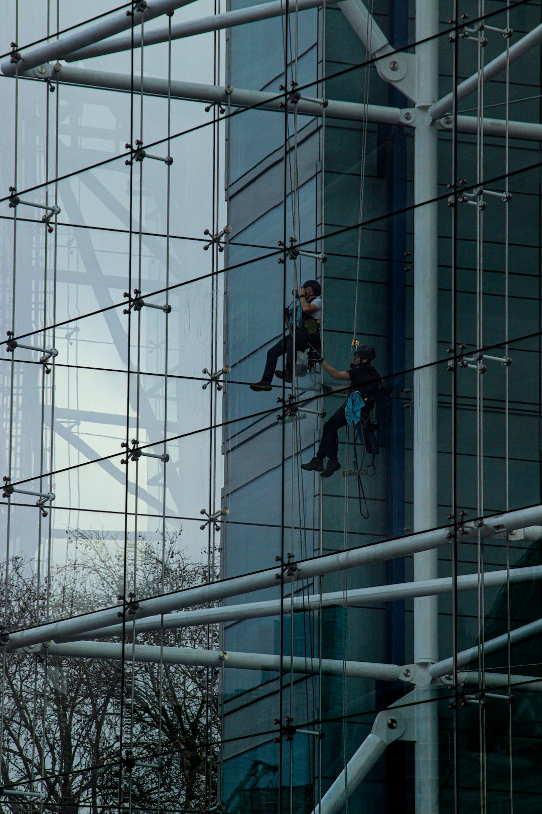 Window cleaners working from ropes on the inside of a Tower Bridge House London